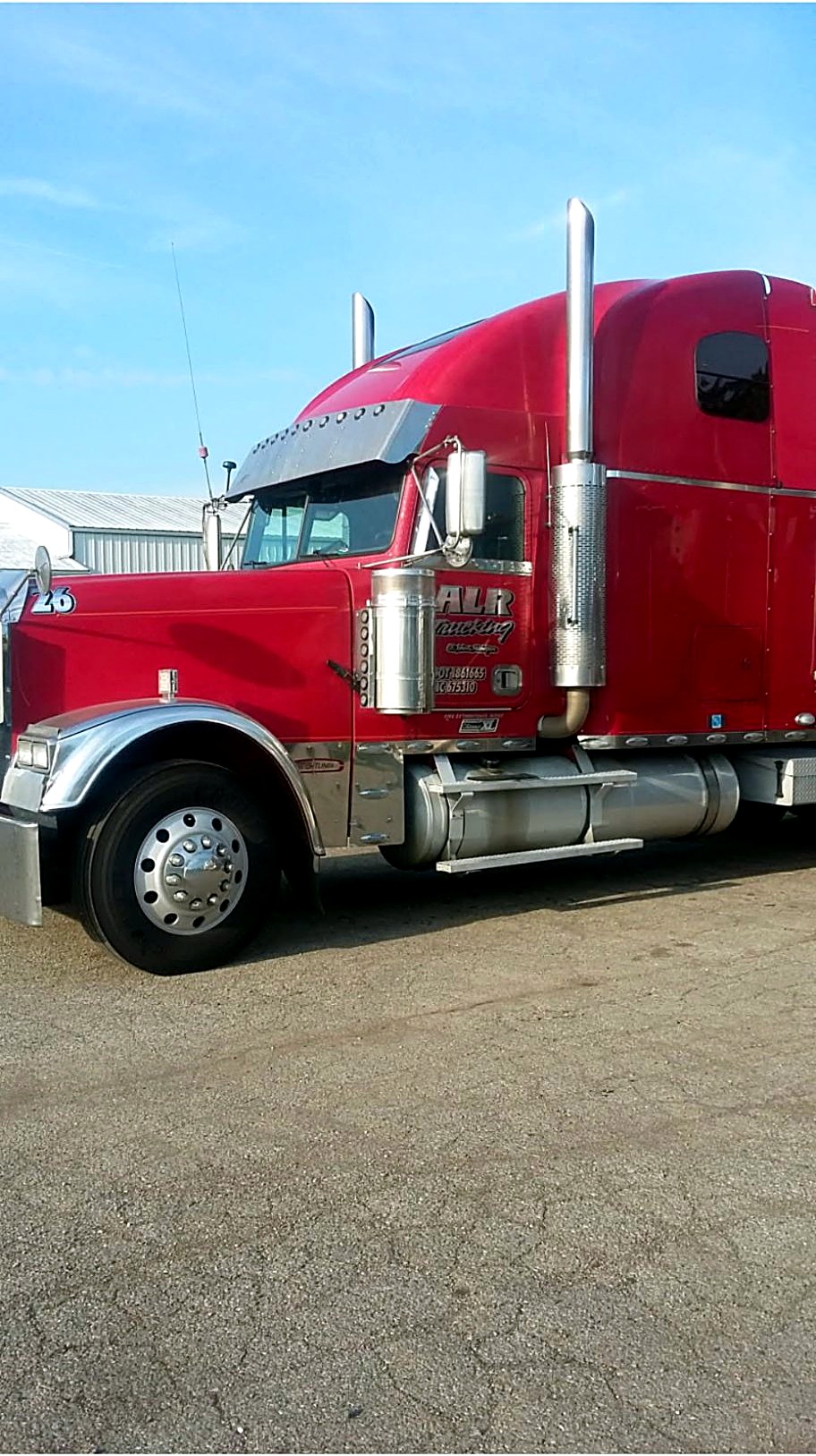 Red ALR Trucking semi number 26 parked outdoors