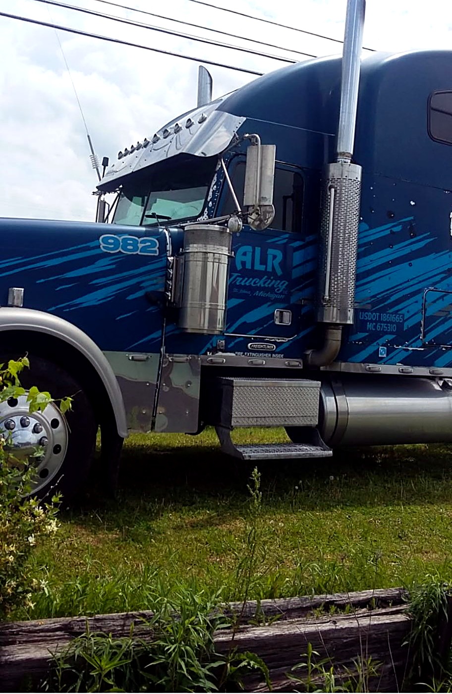 Blue ALR Trucking semi number 982 parked outdoors